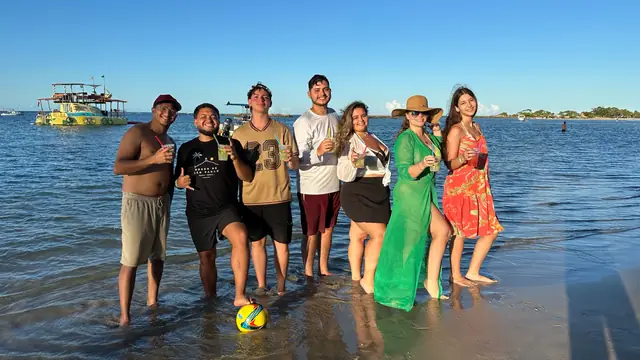 Grupo de viajantes da Mundy brindando na praia em Morro de São Paulo