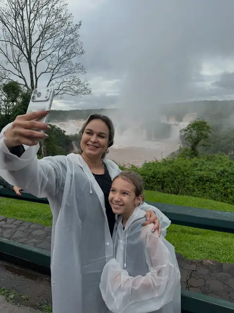Duas viajantes com capa de chuva nas Cataratas do Iguaçu